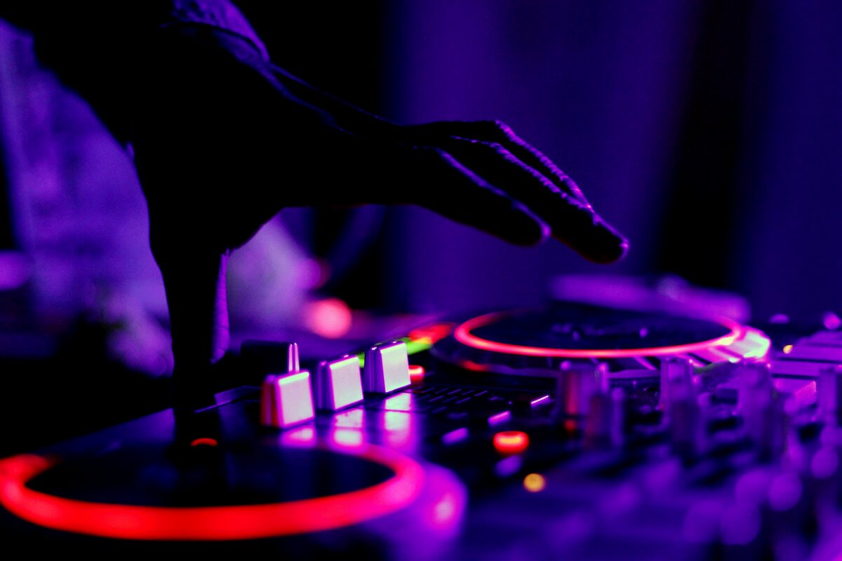 DJ derrière ses platines avec public et éclairages professionnels